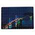 A jigsaw puzzle featuring a brightly lit bridge at night, with various blue and green tones. It has a logo on the corner.
