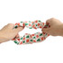 A hair scrunchie featuring a festive design with red snowflakes and green trees. It has a soft, stretchy fabric.