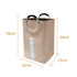 A laundry basket with handles in a beige fabric, featuring measurements of 56cm by 32cm by 25cm.