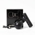 A black mini massage gun beside its box and a charging cable, featuring a sleek design and rounded head.
