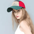 A flat bill cap in red, teal, and cream colours, featuring a logo, worn by a model with long hair.