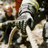Heavy duty safety work gloves in grey with black and yellow accents, featuring a reinforced thumb web design.