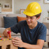 A yellow PVC construction hat worn by a young person working on a wooden project at a table.