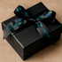 A black gift box wrapped in satin polyester ribbon featuring a blue logo and text.
