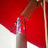 A close-up view of a chrome mechanism on a red commercial market umbrella, featuring a sturdy pole and attachment details.