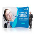 An S-shaped tension fabric display wall featuring a smiling woman in a dental chair and a man in a suit. An S-shaped tension fabric display wall featuring a smiling woman in a dental chair and a man in a suit.