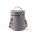 A cylindrical lunch bag in grey fabric with a brown shoulder strap and zip closure, featuring a logo.