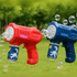 A red and a blue bubble gun, both with bottle attachments, shooting bubbles in a grassy outdoor setting.