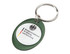 A green oval keyring featuring a logo within a clear lens. The keyring has a silver metal keyring attachment.