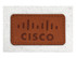 A tan leather patch with a logo on a light beige fabric background.