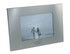 A silver photo frame with a rectangular shape, featuring a central opening for a photo and a logo on the bottom.