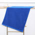 A blue gym towel is draped over a shelf, with a cup and saucer positioned beside it. The towel has a neat trim. A blue gym towel is draped over a shelf, with a cup and saucer positioned beside it. The towel has a neat trim.