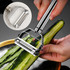 A stainless steel vegetable peeler with a sleek handle, being used to peel a cucumber in a bowl.