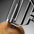 A stainless steel vegetable peeler with a sleek design, featuring a polished finish and a logo on the handle.