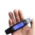 A black digital luggage scale held in a hand, displaying a blue backlit screen with a weight reading.
