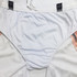 Breathable soccer shorts in white and peach, featuring lining and an elastic waistband. Includes a logo.