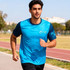 A man jogs in a vibrant blue and navy 100% polyester sublimated tee shirt with a logo on it.