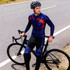 Men's sublimated cycling tights in navy with red and blue graphics, worn by a cyclist beside a bicycle on a road.