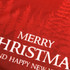 A red sweatshirt featuring a forest design and white text stating "Merry Christmas and Happy New Year."