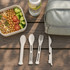 A set of white portable utensils including a spoon, fork, knife, and spork, alongside a drink bottle and meal container.