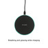 A round, black wireless charger with a glowing edge, connected to a power source. It features a logo.