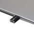 A black USB data blocker is plugged into a silver laptop, highlighting its sleek and compact design.