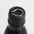 A drink bottle with a black stainless steel body and a metallic loop on the cap for easy handling.