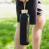 A drink bottle in matte black with a natural wooden cap, featuring a sleek design and a carrying strap.
