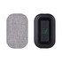 A wireless charger with a textured grey fabric surface and a black body, featuring a logo on one side.