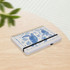 A4 wiro side bound notebook with a blue sea turtle design, featuring a black elastic band, resting on a wooden surface.