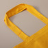 A yellow tote bag featuring sturdy handles and a simple yet stylish design. The bag has a logo on one side.