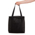 A black cooler bag with sturdy handles being held by a hand. The bag has a front pocket and a zipper closure.