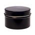 A petite black candle in a tin container with a smooth lid. The minimalist design features a sleek finish.