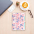 A4 expandable file folder in pink with floral patterns, placed on a wooden desk alongside a coffee cup, glasses, and a laptop.