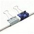 Two decorative binder clips in light blue and dark blue patterns sitting on a stack of white paper.