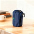 A packable travel backpack in navy blue, secured with a drawstring and featuring a carabiner clip.