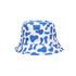 A blue and white bucket hat featuring a cow print pattern, with a branded logo on the side.