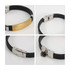 A metal buckle latch bracelet featuring a gold and silver design with a black band. Includes branding on the metal.