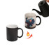 A black colour-changing mug, revealing a colourful design when hot liquid is poured in, with a hand pouring water.