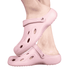 Pink clog slides with a textured surface and ventilation holes, featuring a simple logo on the side.
