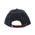 A black cap with a curved brim, featuring red cotton twill contrast piping and an adjustable strap at the back.