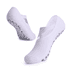 A pair of white yoga socks with a non-slip dotted sole and crisscross design. Features a logo on one sock.