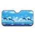 A foldable car sunshade featuring a vibrant blue ocean scene with dolphins leaping against a sky backdrop.
