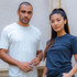A light grey men's cotton crew t-shirt and a black women's cotton crew t-shirt on models. Both shirts have logos.