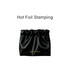 A black zipperless portable makeup bag with a gathered top and gold branding, featuring a smooth satin finish.