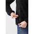 A black women's Bergen Sherpa fleece jacket featuring zippered pockets, shown on a model's hand.