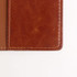 A RFID PU leather passport holder in a rich brown colour with visible stitching details. It features a subtle branding element.