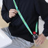 A drink bottle lanyard in green, worn diagonally across a person’s body, holding a water bottle.