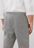 A pair of mens track pants in a black and white checkered pattern, featuring a waistband and pockets on the back.