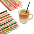 A variety of colourful paper straws in different patterns alongside a cup of coffee with a black straw.